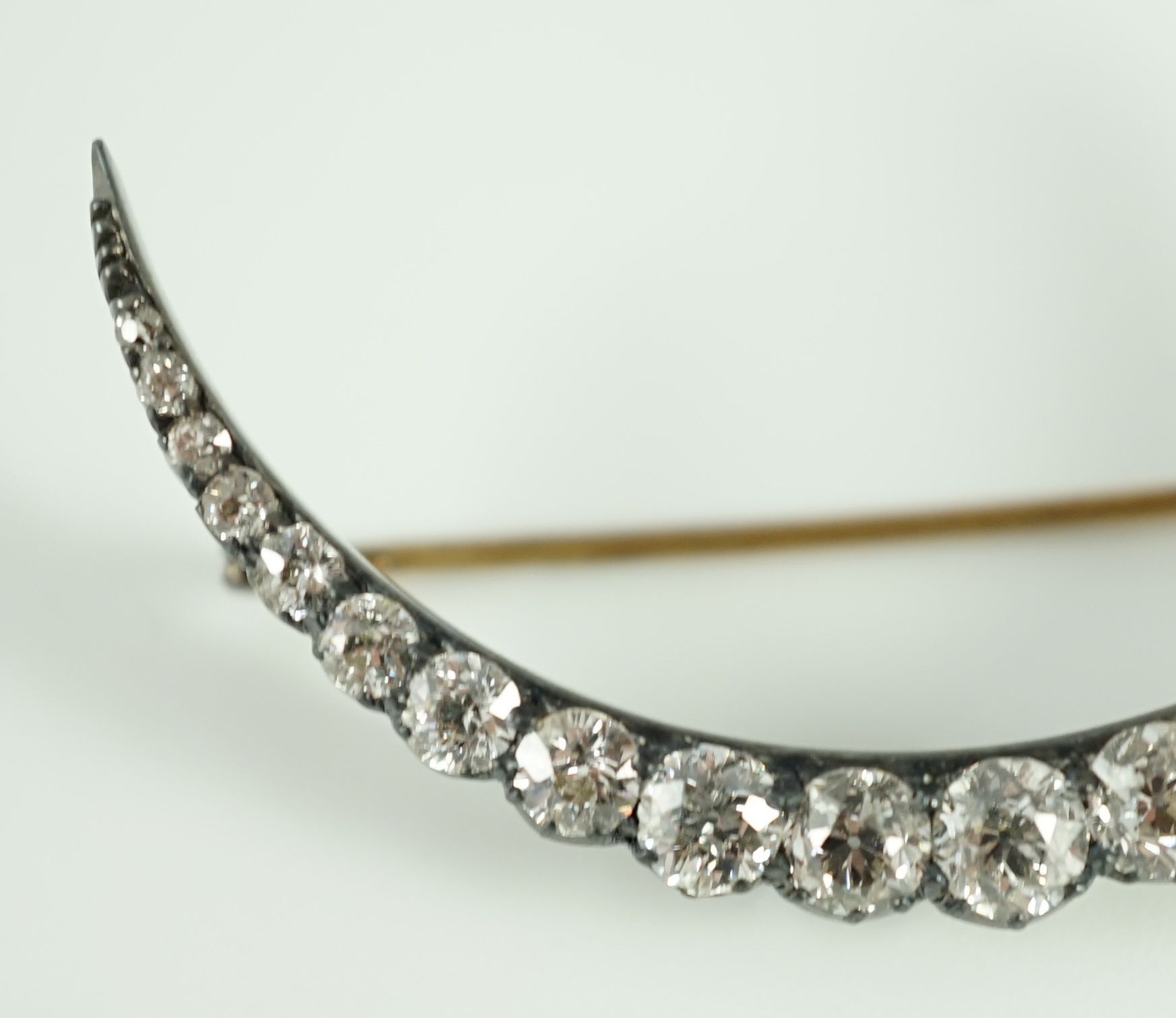 A Victorian, gold, silver and graduated twenty one stone diamond set crescent brooch